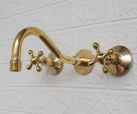 unlacquered brass wall mounted faucet with cross handles