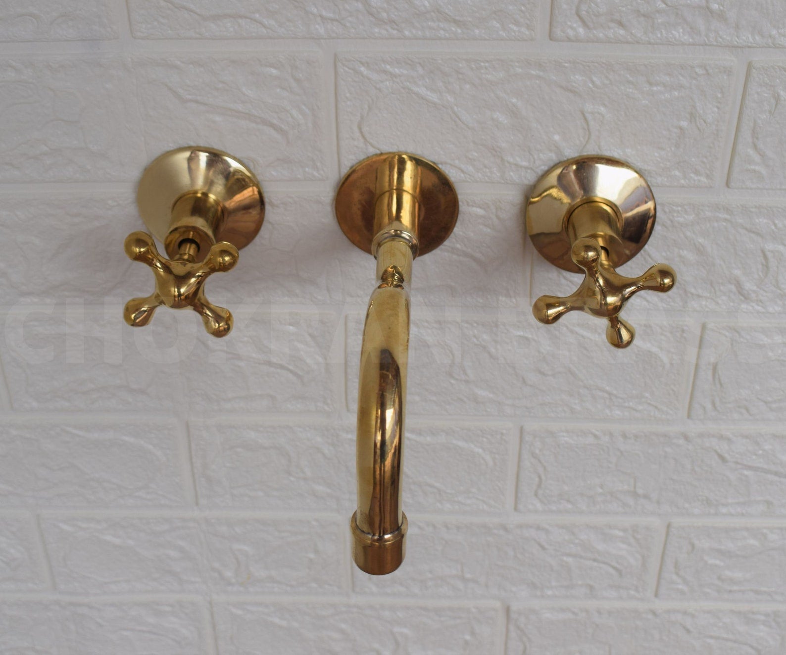 unlacquered brass wall mounted faucet with curved spout