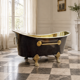 A freestanding clawfoot bathtub with a glossy black exterior and antique brass interior