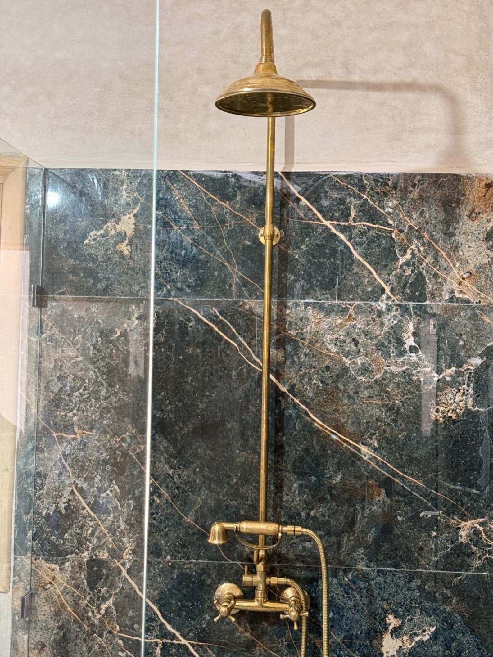 unlacquered brass shower with handheld