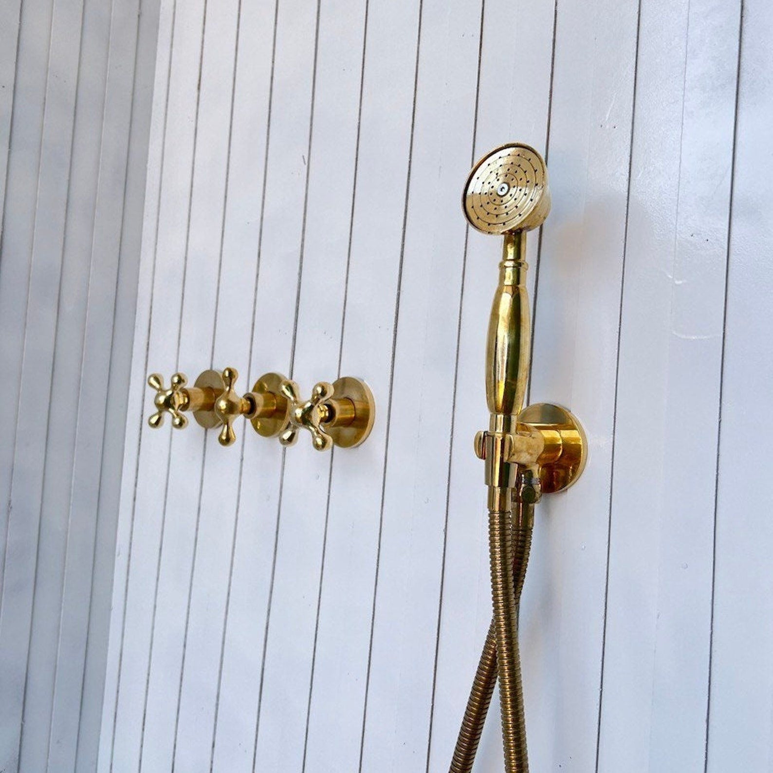 unlacquered brass wall mounted shower with hand shower